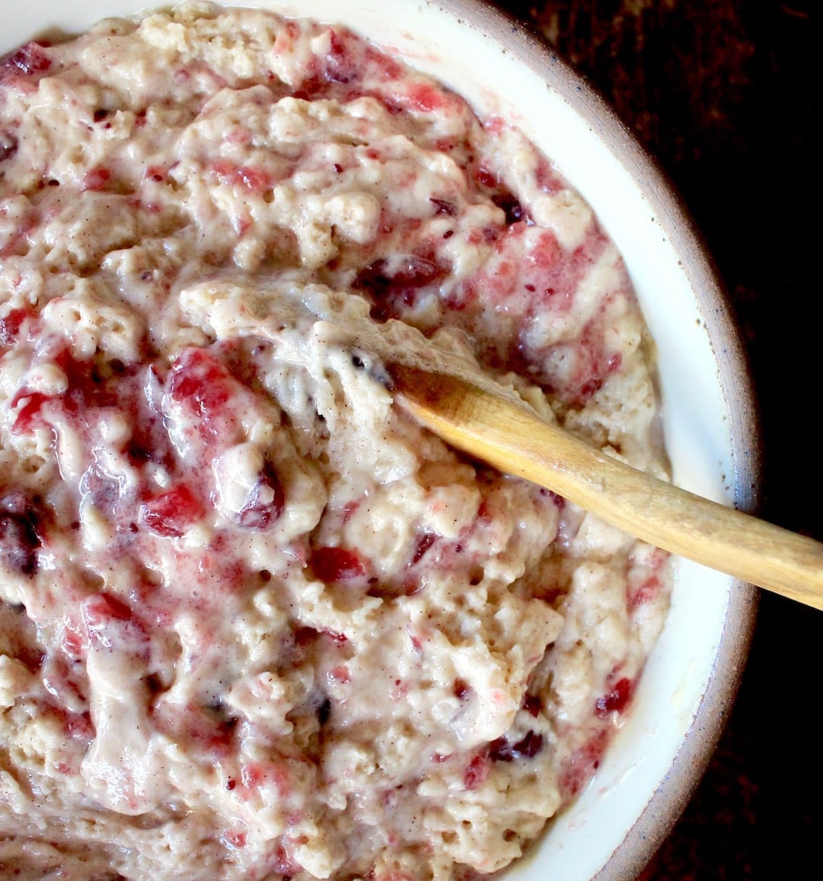 Leftover cranberry sauce muffin batter in bowl with wooden spoon.