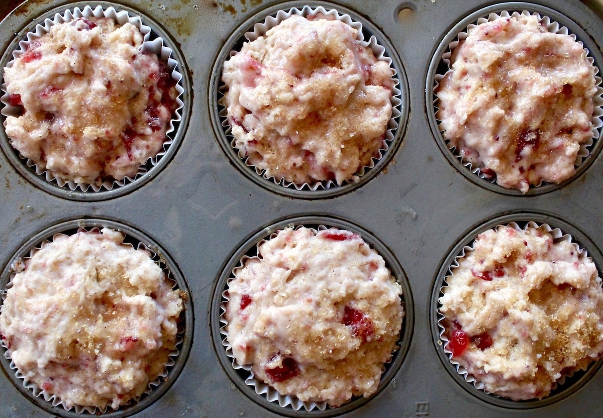 Muffin pan fill with batter for leftover cranberry sauce muffins in muffin pan.