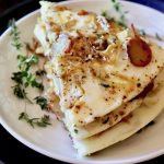 Three stacked slices of an egg white frittata on a white plate.