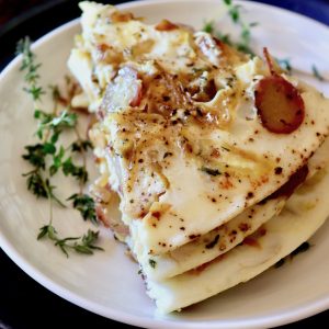 Three stacked slices of an egg white frittata on a white plate.