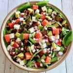 Top view of a serving bowl full with watermelon basil salad with feta and avocado.