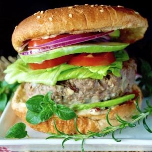 Close up of a Grilled Mediterranean Burger in a bun with all the fixins.