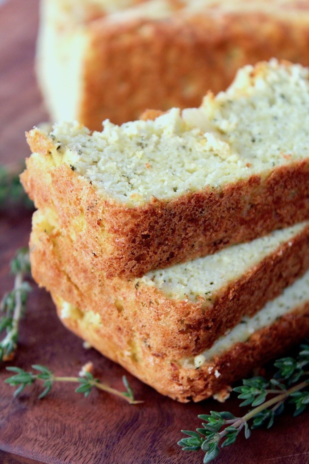 Three slices of cauliflower bread on cutting board.