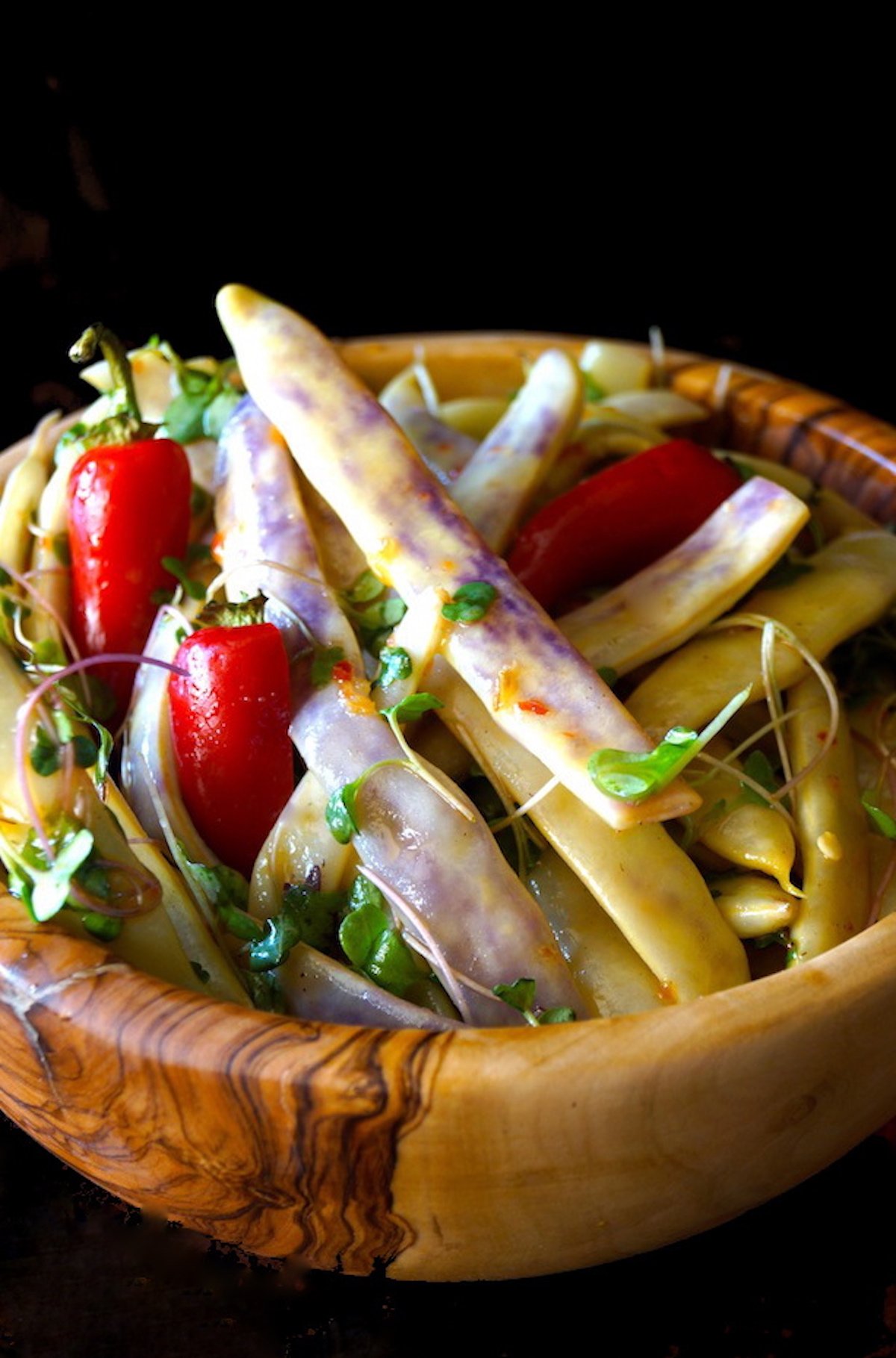 Dragon Tongue Bean Salad in a wooden bowl with bright red peppers.