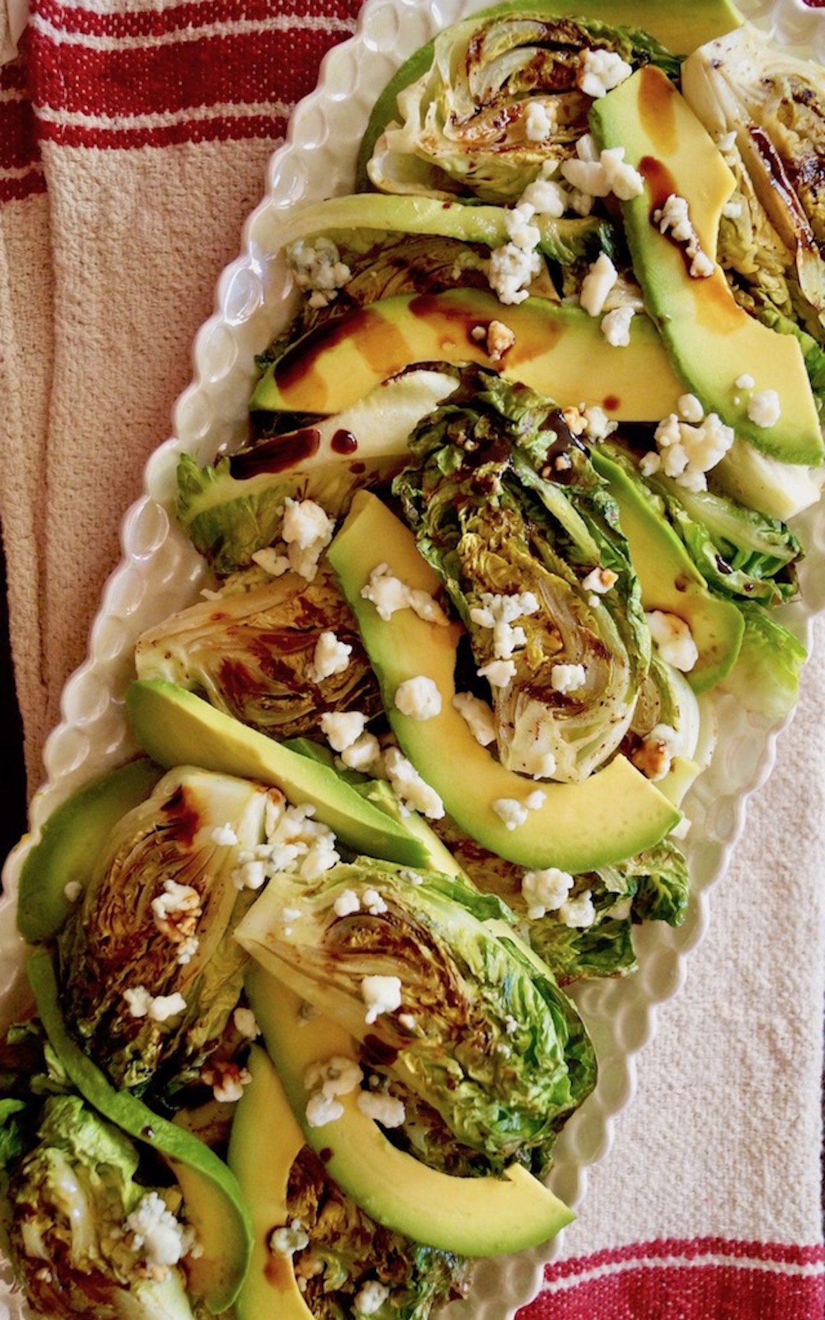 Little Gem Lettuce Salad with avocado slices on white plate