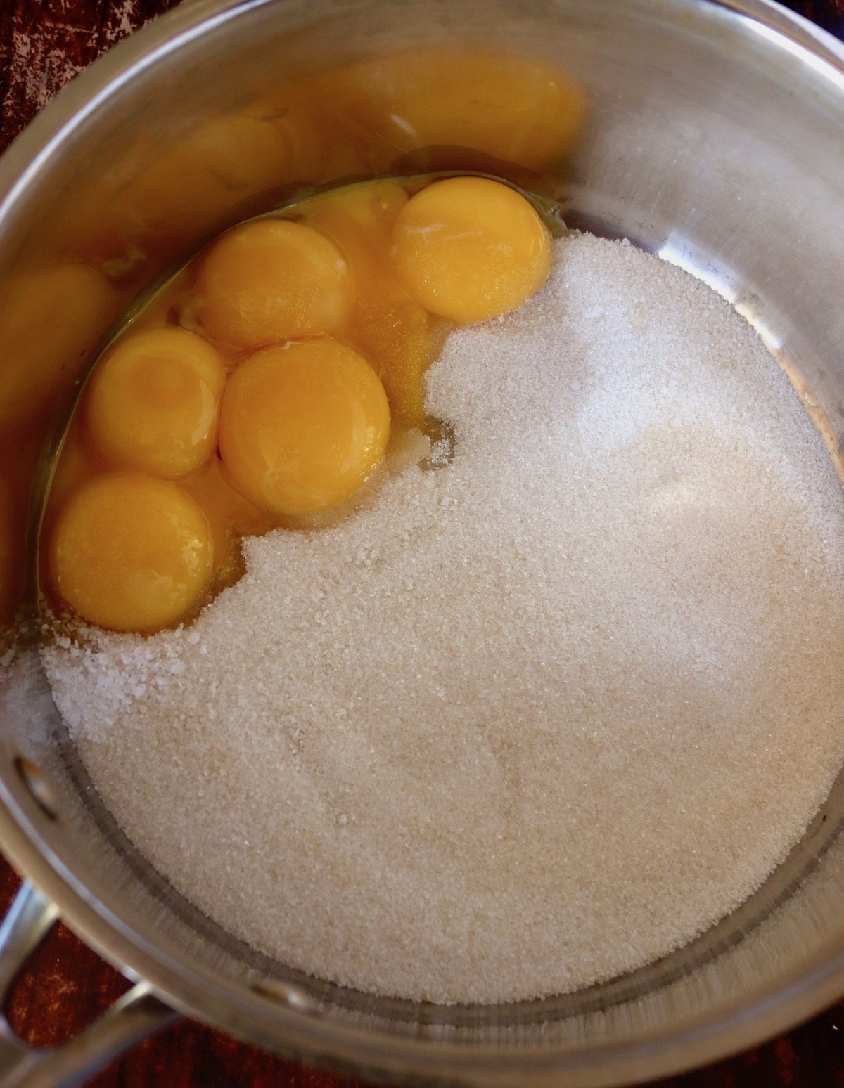 6 egg yolks in a pot with granulated sugar.