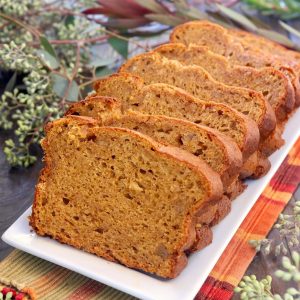 Sliced loaf of Butternut Squash Bread on white platter.