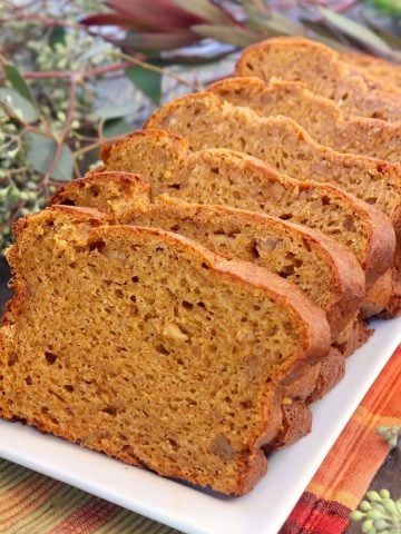 Sliced loaf of Butternut Squash Bread on white platter.