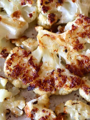 Browned, smashed cauliflower on a baking sheet.
