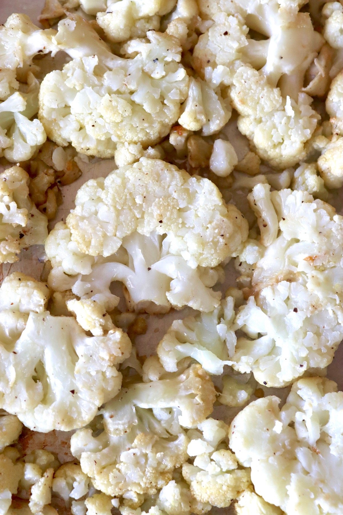 Sheet pan filled with flattened pieces of cauliflower.