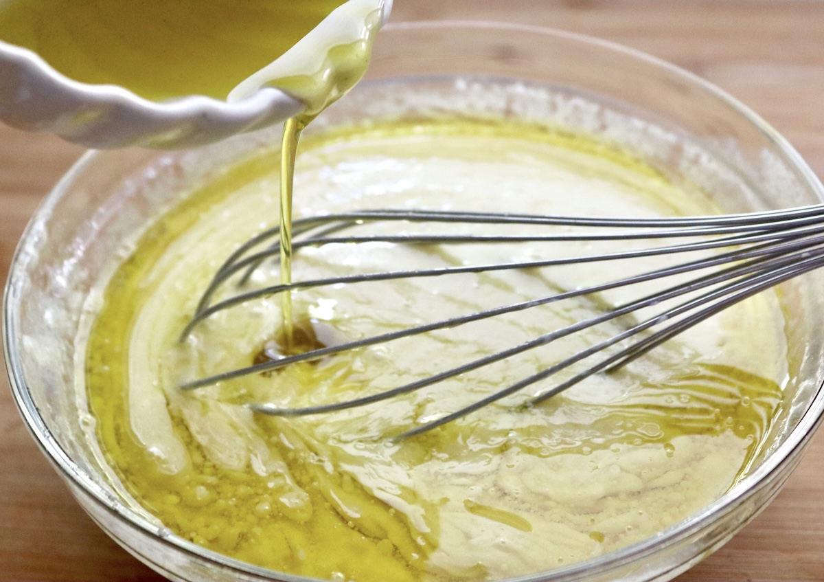 Egg, sugar, and sour cream mixture, with olive oil being whisked into it - for gluten-free dark chocolate cake batter.