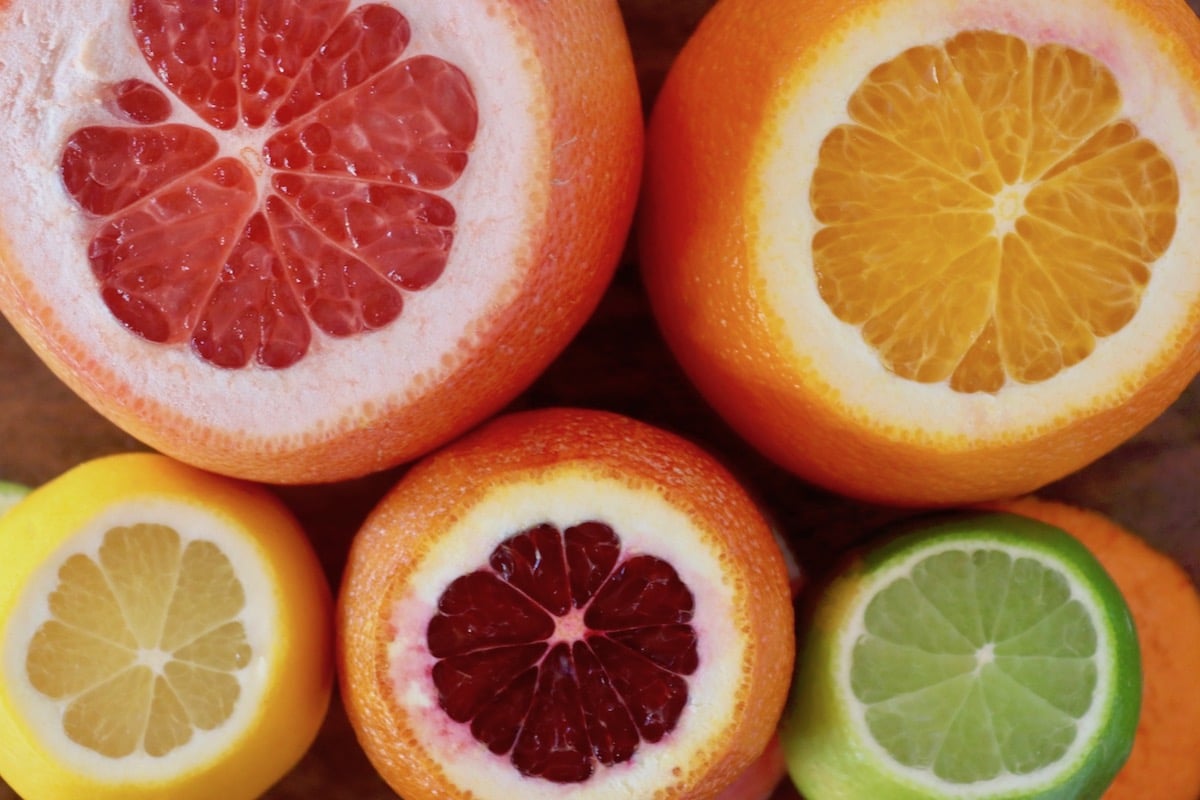 Grapefruit, orange, lime, lemon and blood orange, each with about an inch cut off the top.