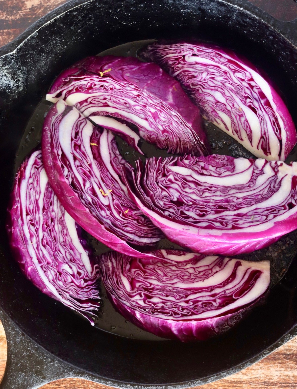 raw red cabbage wedges in a cast iron skillet.