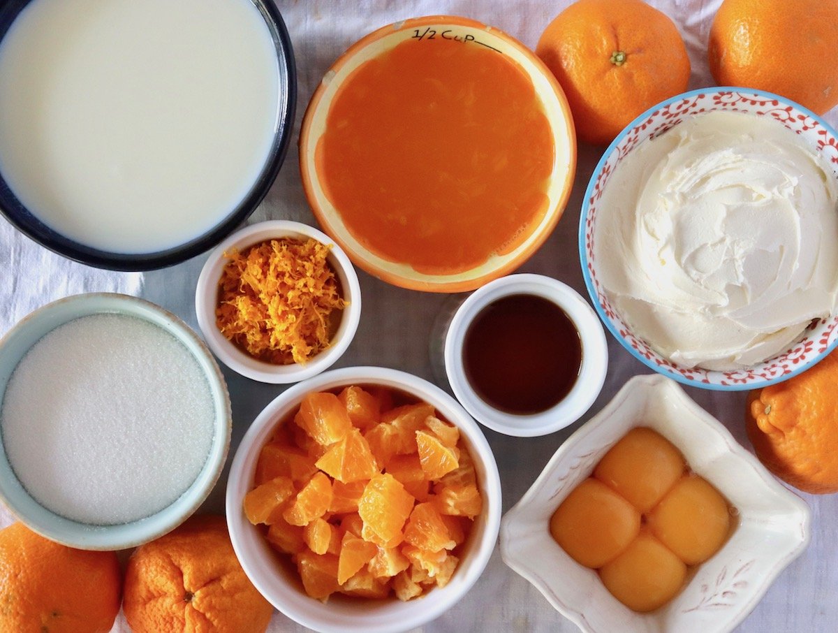 Several bowls of ingredients for creamsicle ice cream including yolks, tangerine zest, juice and pieces, milk, sugar, vanilla and mascarpone.