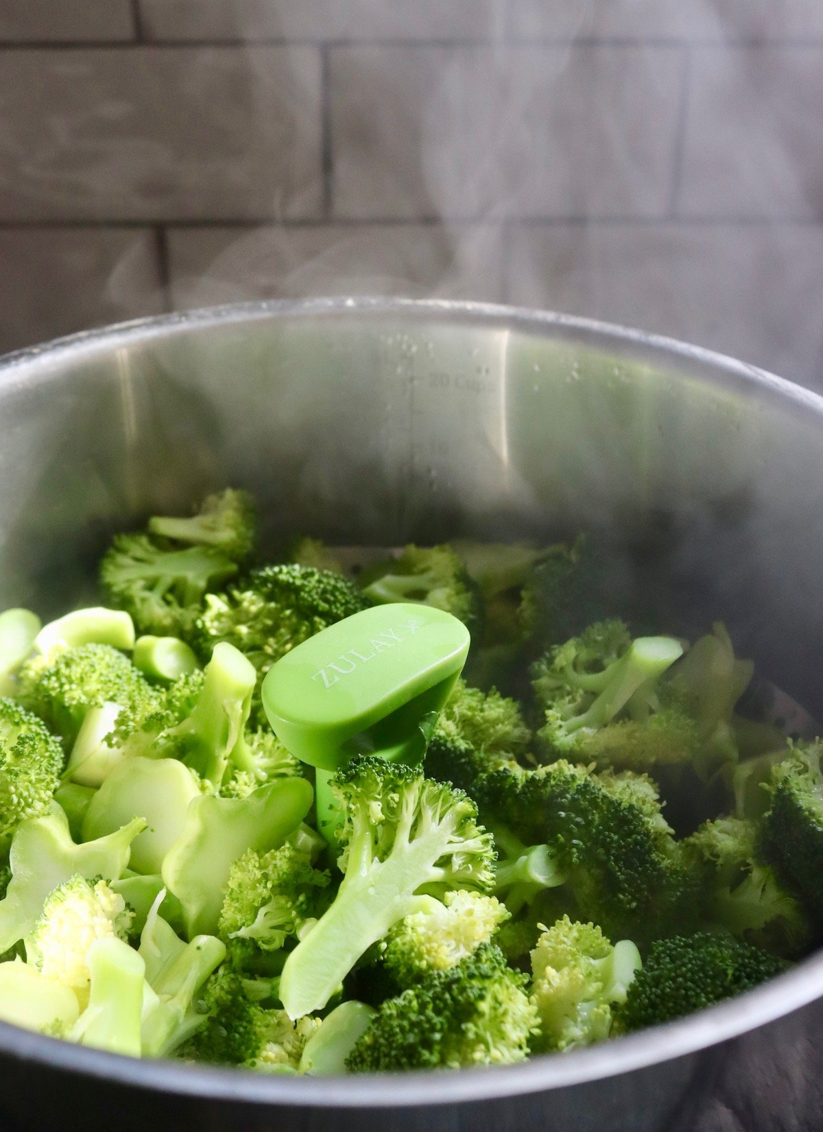 Pot with freshly steamed broccoli, with steam coming from it.