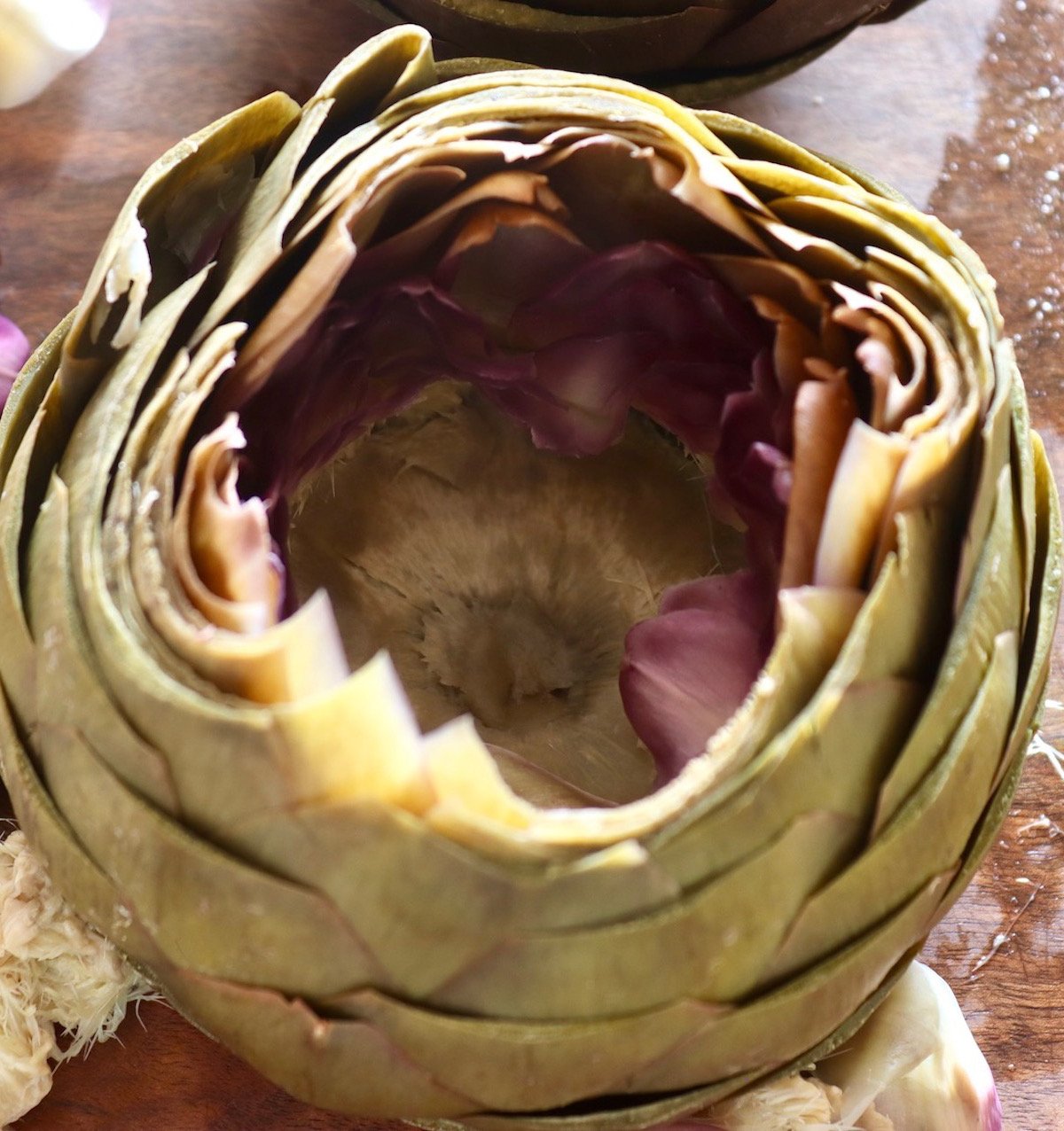 Top view of a steamed artichoke with the choke remove, revealing the heart.