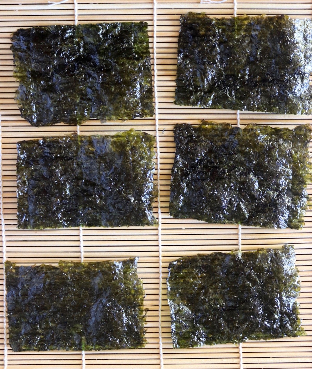 6 snack-sized Nori sheets on a sushi mat.