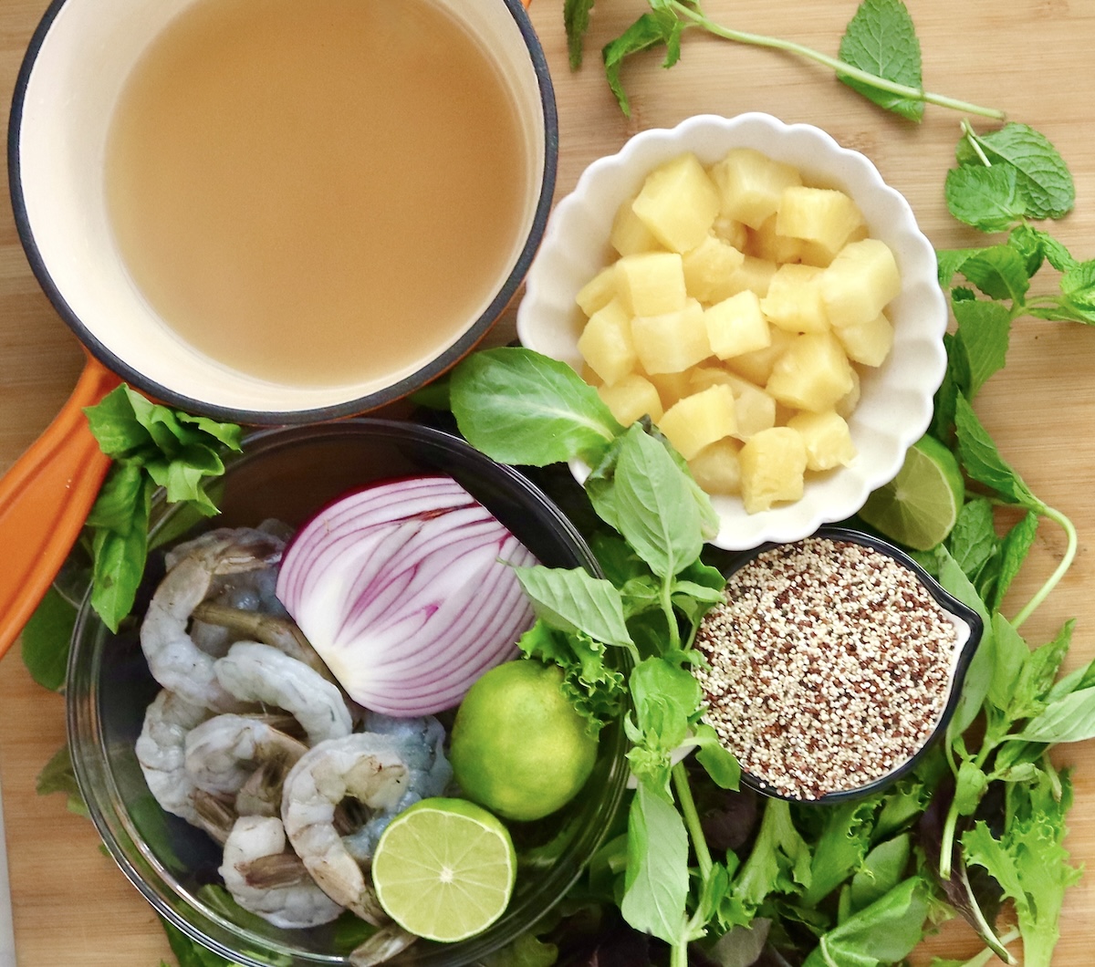 Shrimp-Quinoa-Bowl Ingredients for shrimp quinoa bowl including pineapple chunks,pineapple juice, red onion, dry quinoa, raw peeled shrimp, fresh mint and basil, baby lettuce and lime.
