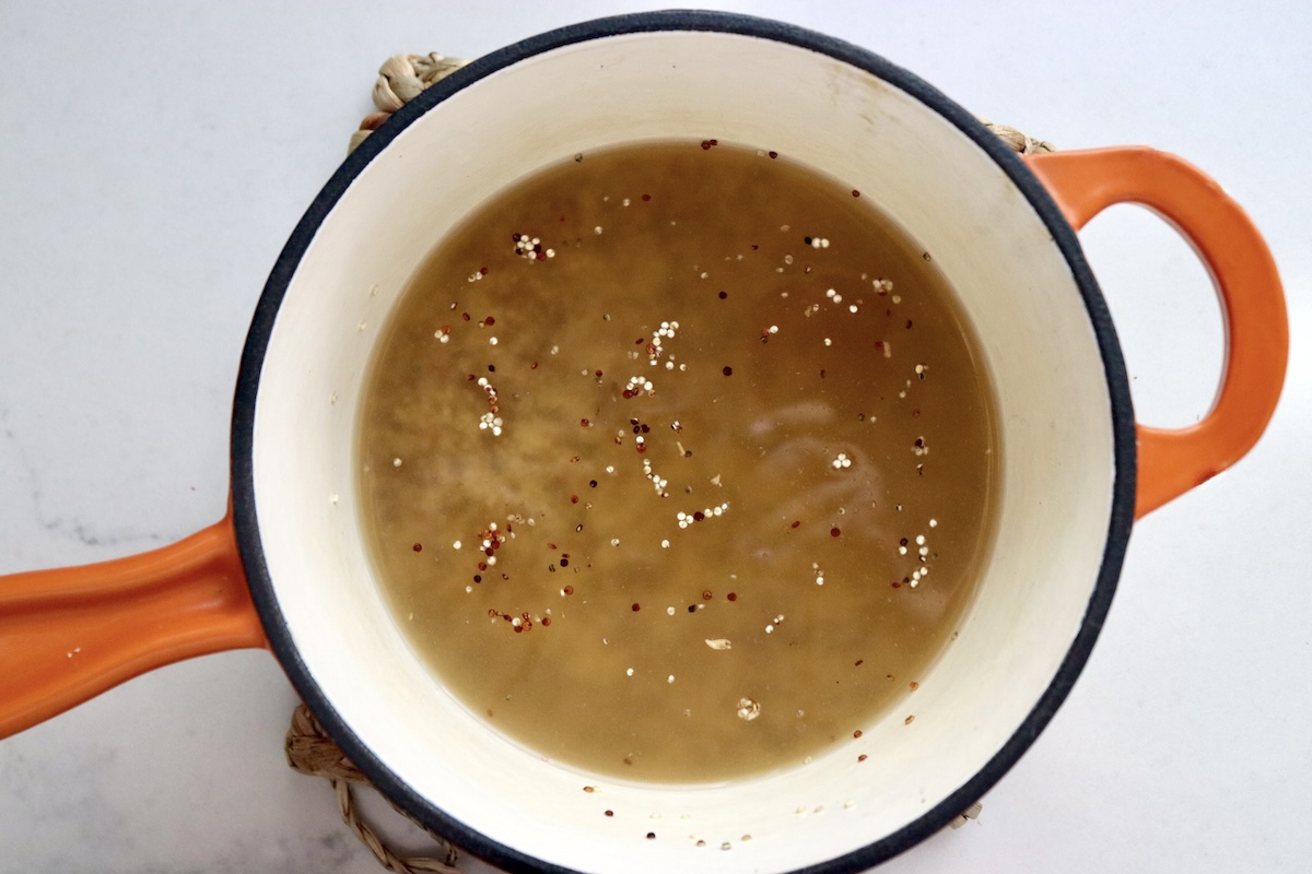 Quinoa in a pot with a mix of pineapple juice and coconut water with a touch of soy sauce.