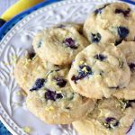 Cream-colored plate on top of a blue-rimmed plate with layered lemon blueberry cookies.