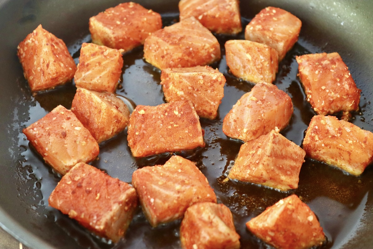 Stovetop-Crispy-Salmon-Bites Raw cubed salmon in skillet with olive oil.