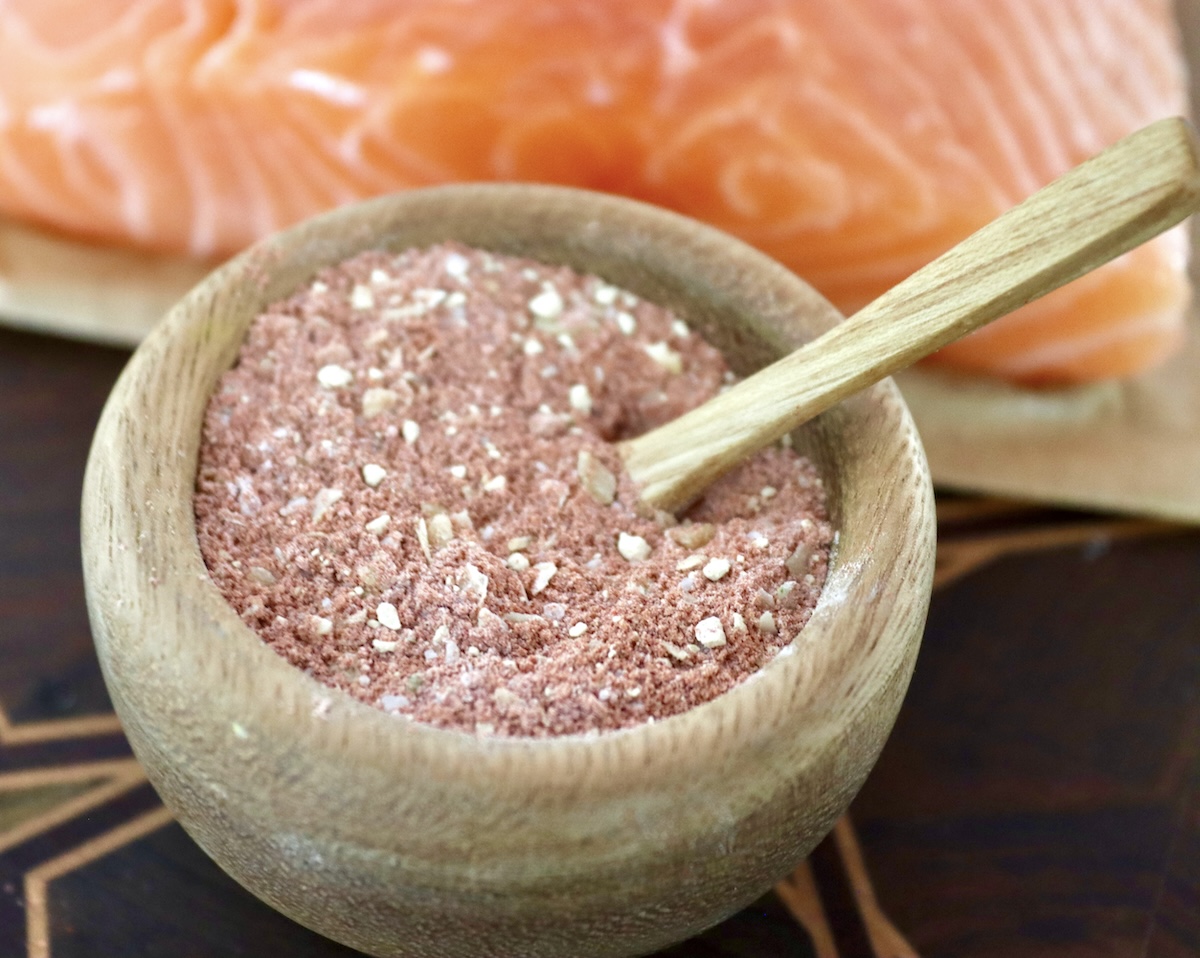 Stovetop-Crispy-Salmon-Bites Small wooden bowl with a spice mix of paprika, garlic, onion, salt and cornstarch, with a tiny wooden spoon.
