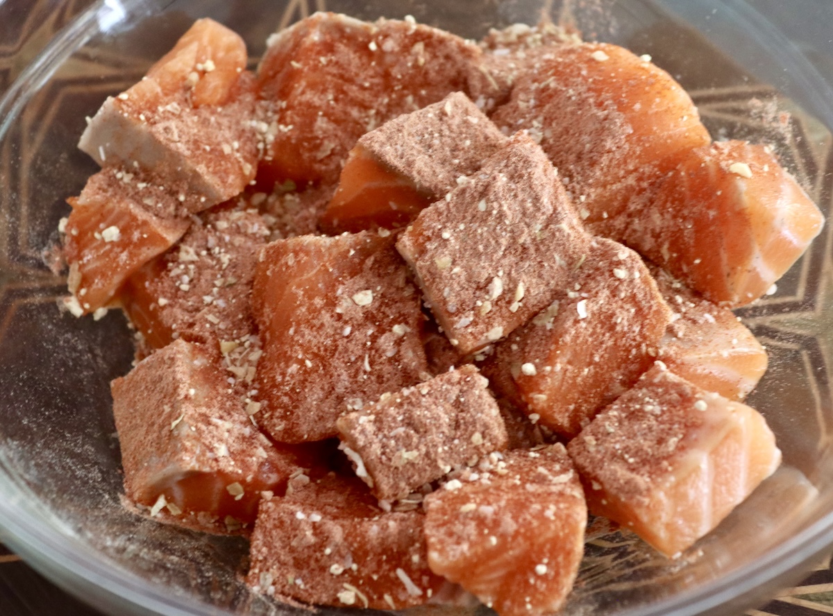 Stovetop-Crispy-Salmon-Bites Raw cubed salmon pieces in a glass bowl with spice rub.