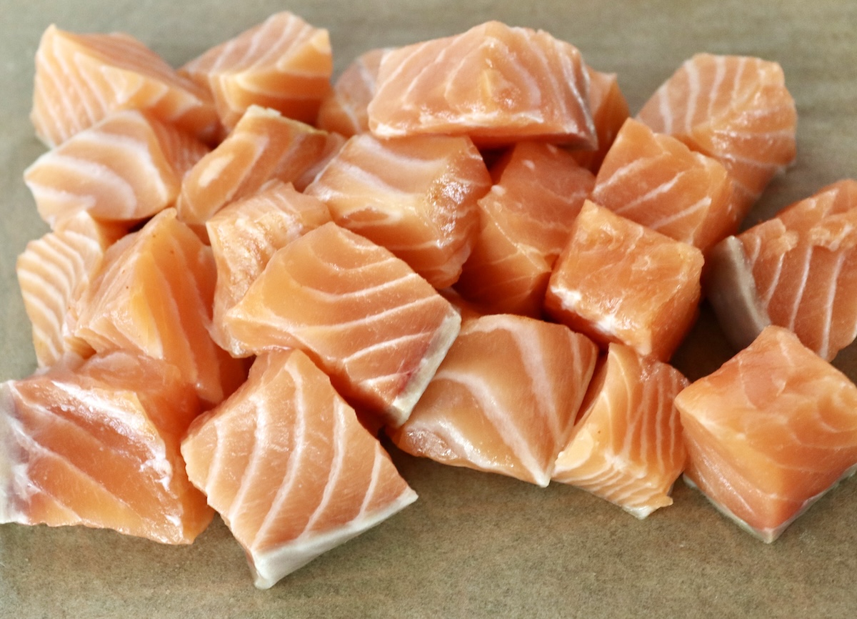 Stovetop-Crispy-Salmon-Bites Raw cubed salmon pieces on parchment paper.