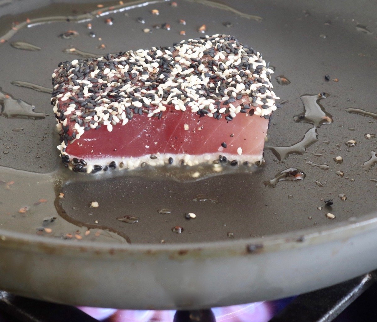 Sesame-crusted Ahi tuna steak in a saute pan.