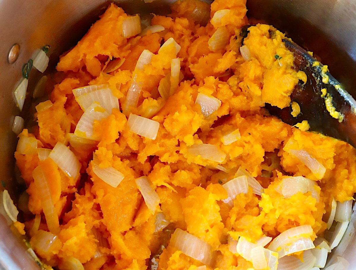 Pureed orange squash and chopped onion in a large soup pot.