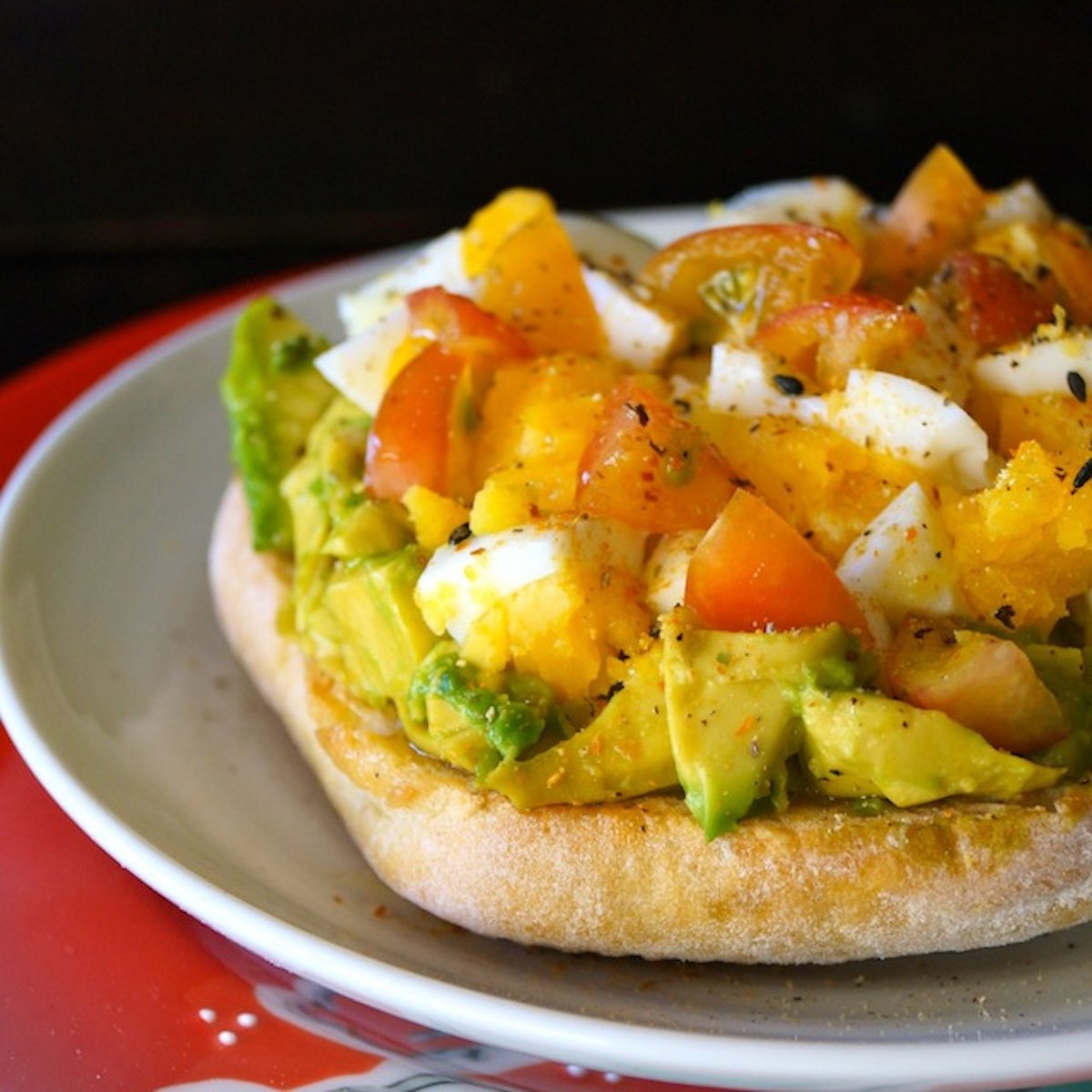Avocado Toast with Egg and tomatoes on a white and red plate