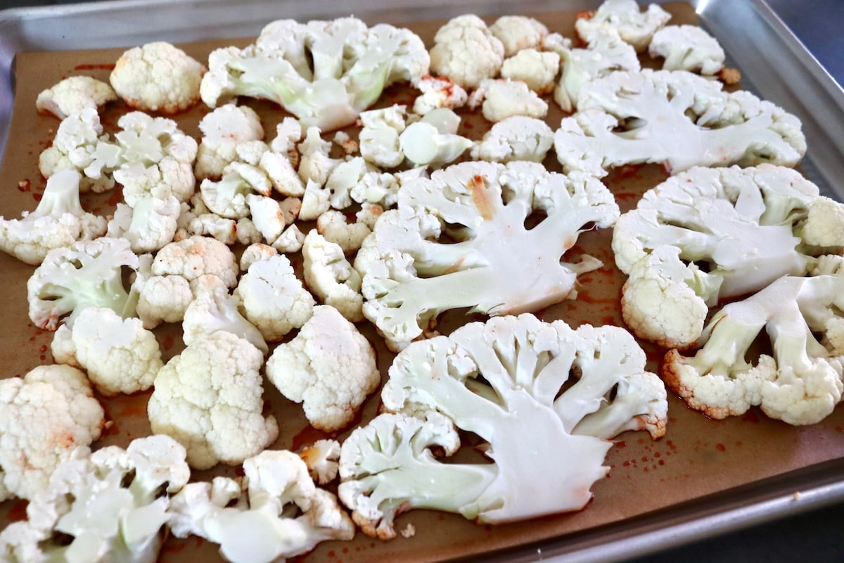 Thick cauliflower slices on a parchment-lined sheet pan.