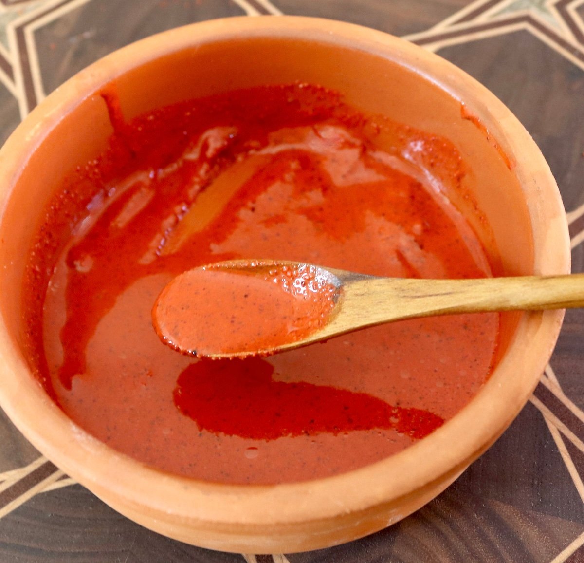 Small terra cotta bowl with red achiote sauce.