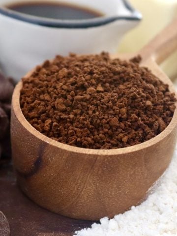 Coarse coffee grounds in a wooden coffee spoon.