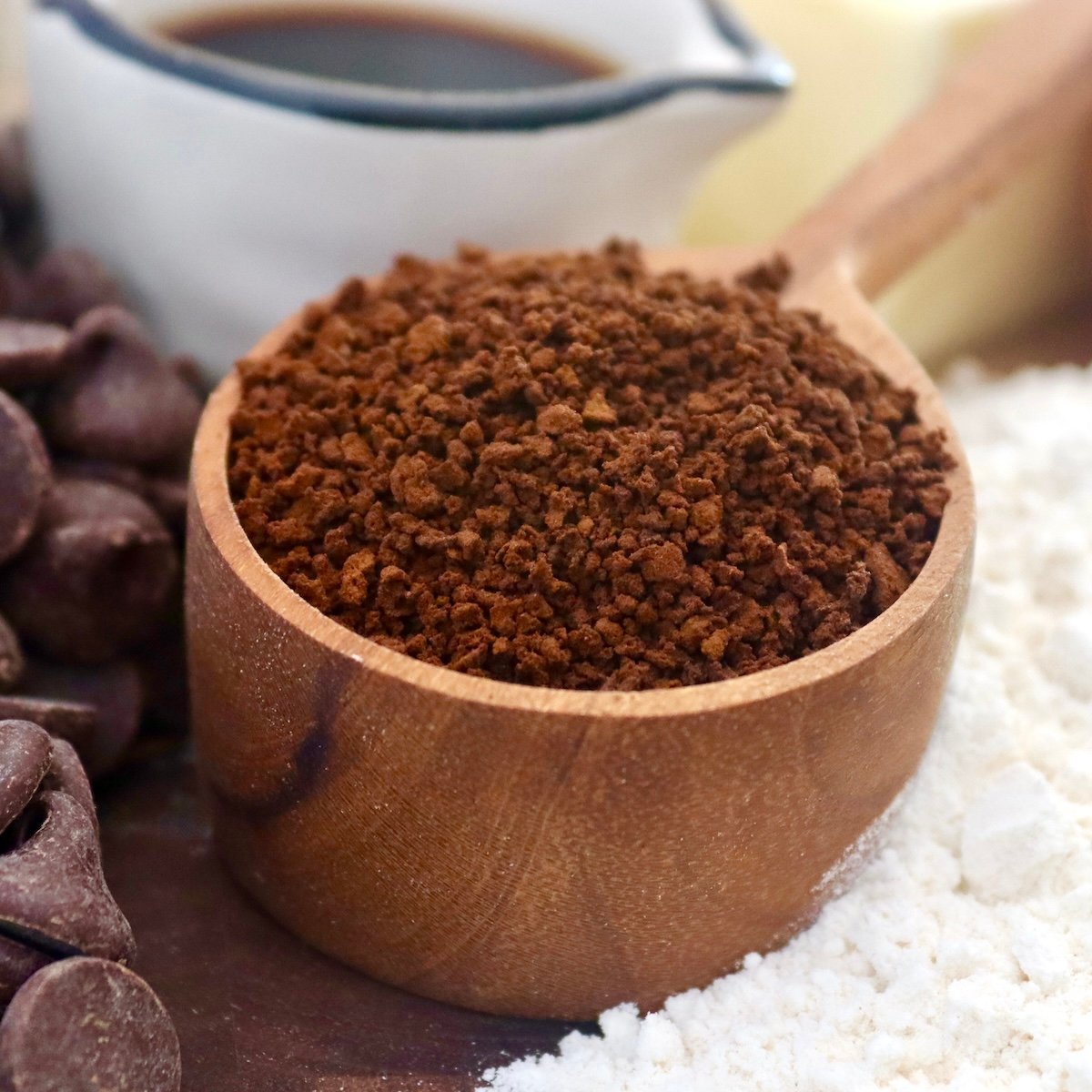Coarse coffee grounds in a wooden coffee spoon.