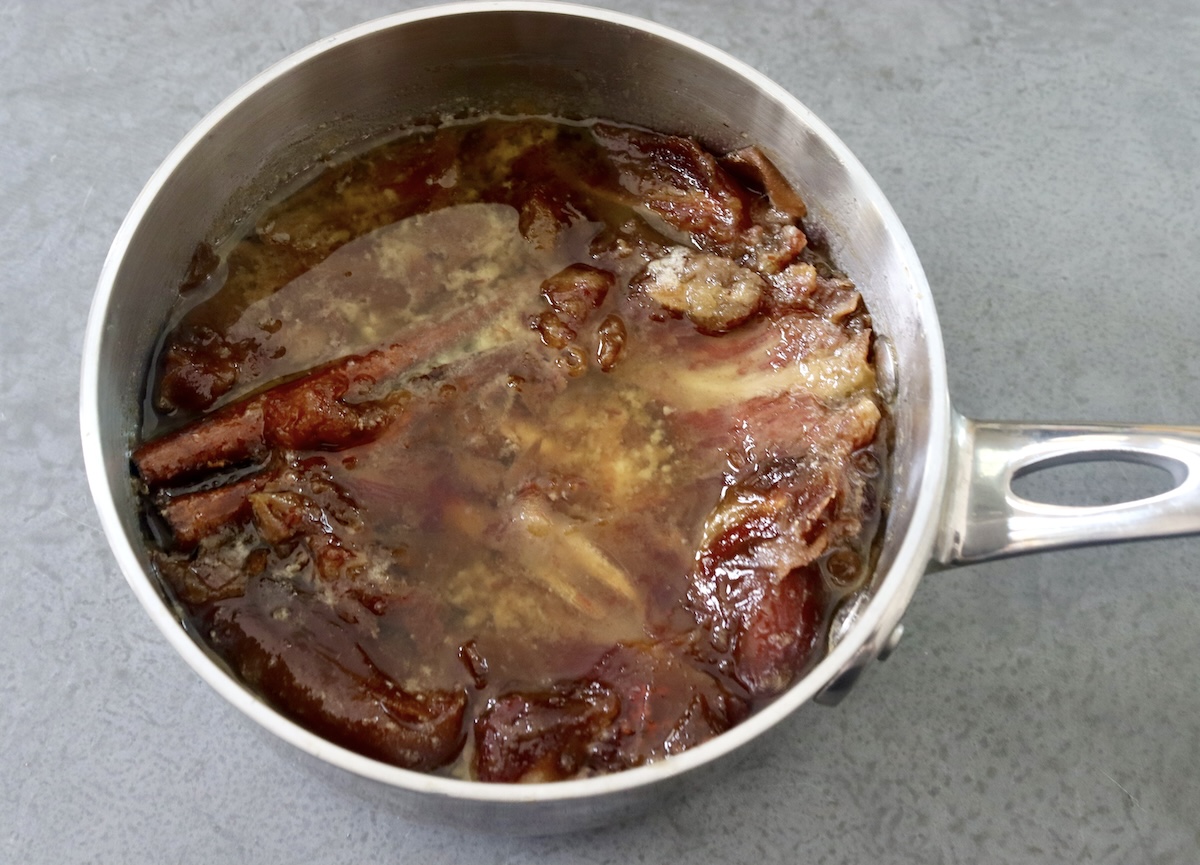 Hydrated dates in a pot with melted butter and cinnamon stick.