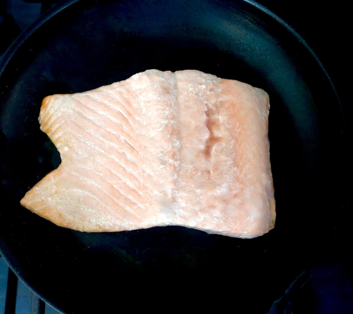 Cooked salmon fillet in a saute pan.