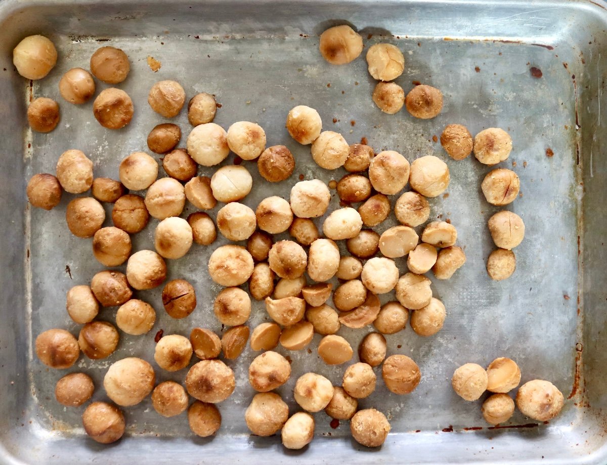 Small sheet pan filled with roasted macadamia nuts.