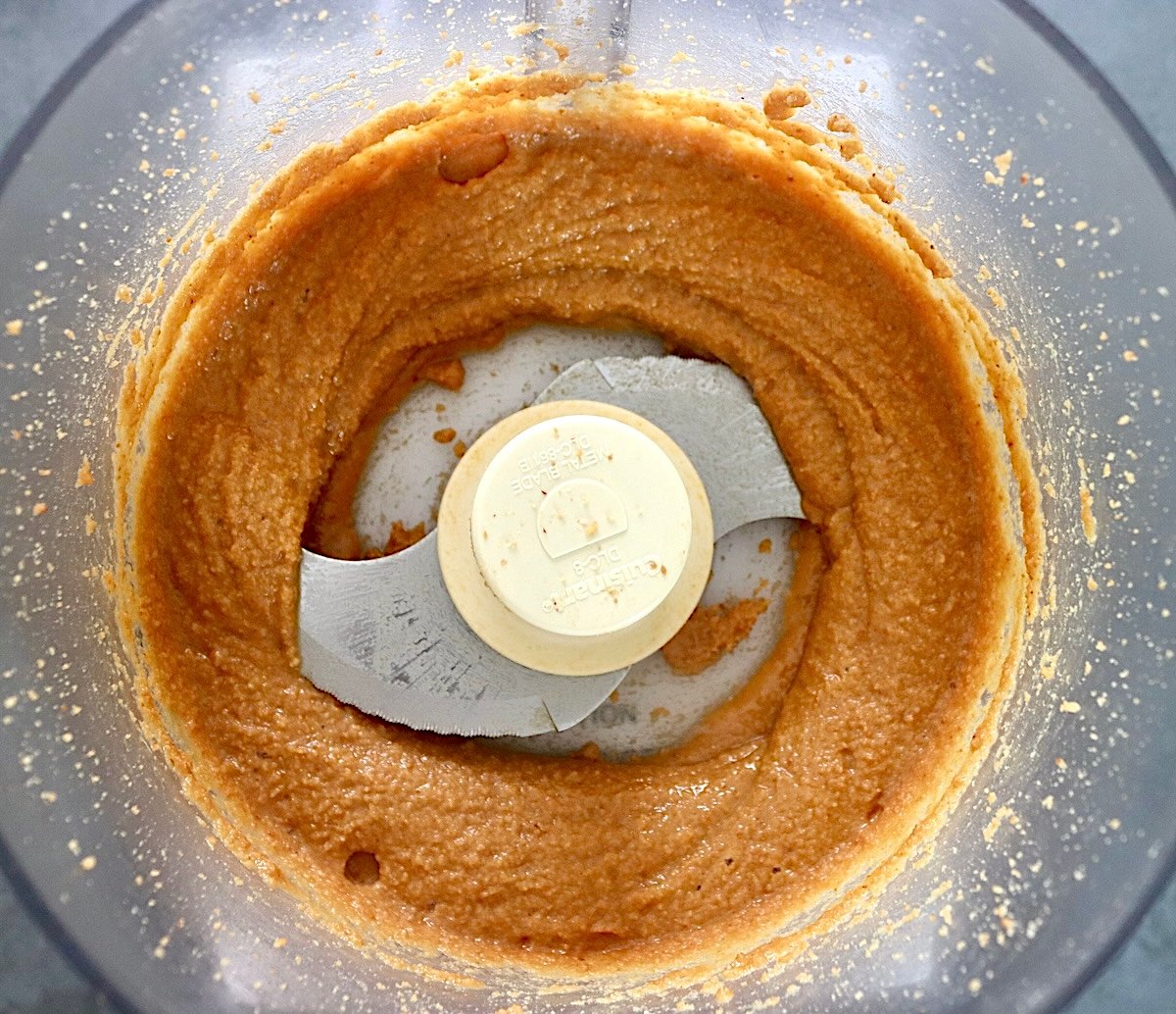 Macadamia buter in a food processor bowl.