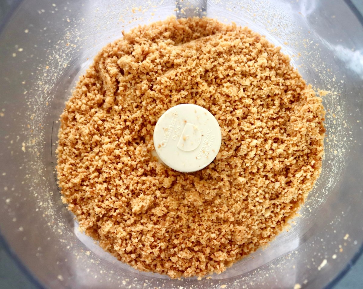 Finely ground macadamia nuts  in a food processor bowl.