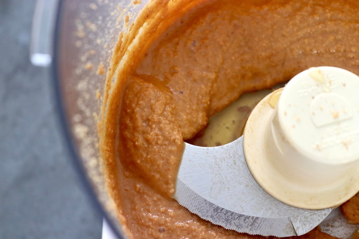 Macadamia nut butter with honey in a food processor bowl.