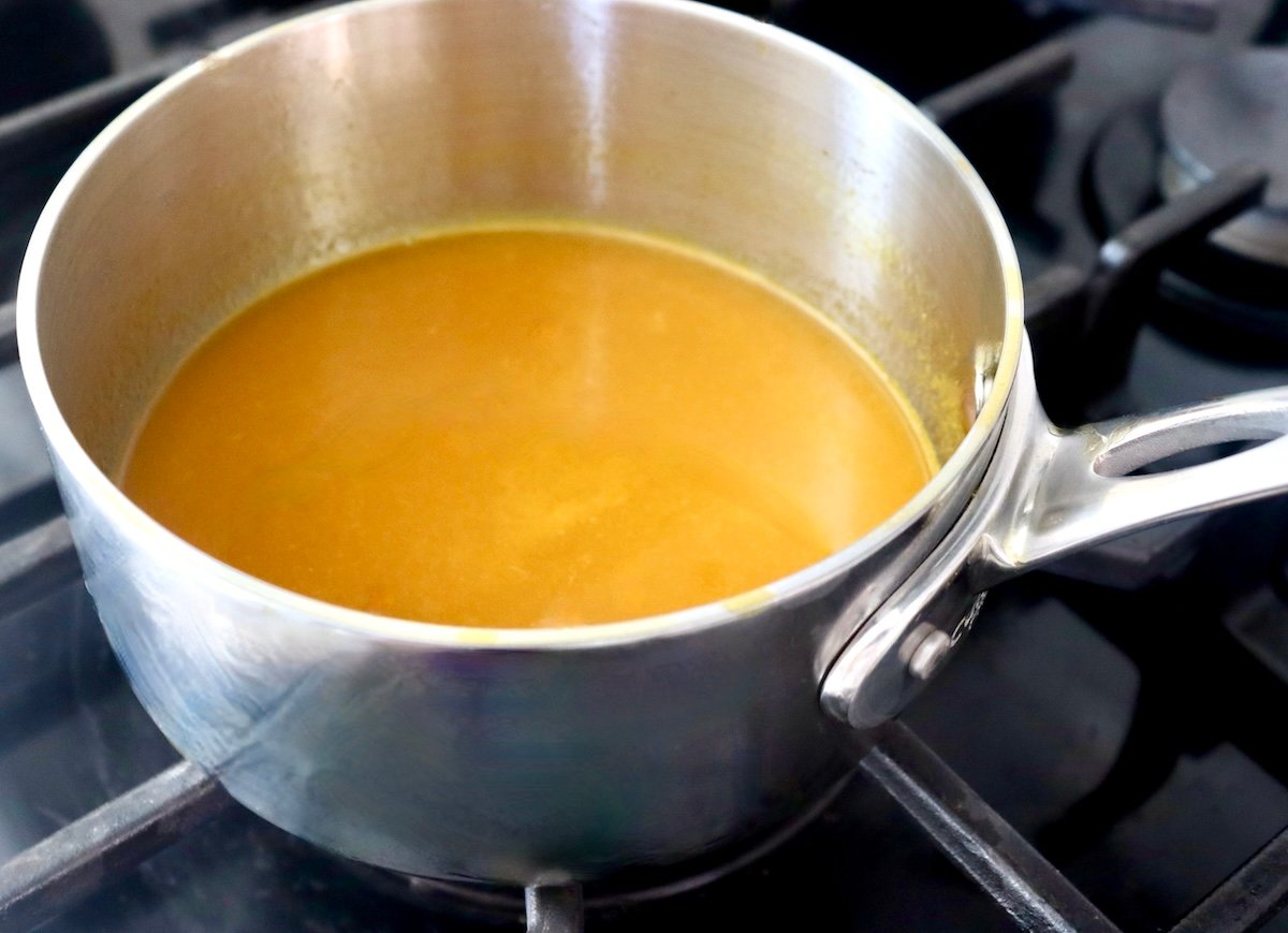 Saucepan with passion fruit juice on the stove.
