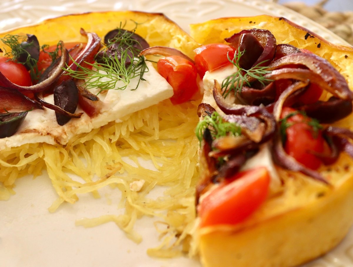 Spaghetti-Squash-Rings-with-Feta-and-Olives One spaghetti squash ring topped with feta, tomatoes and olives, and cut in half.