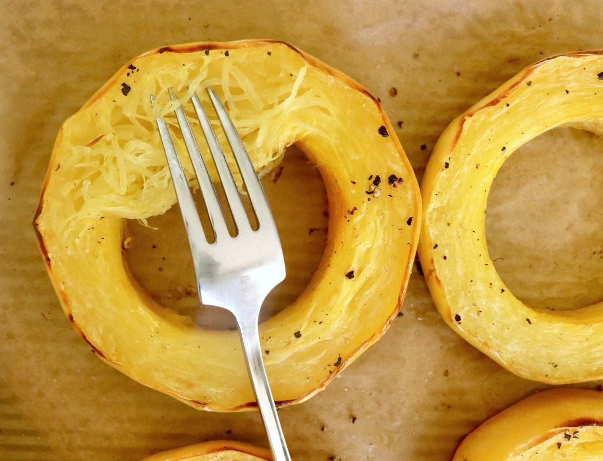 Spaghetti-Squash-Rings-with-Feta-and-Olives Spaghetti squash ring with a fork pulling flesh from the skin.