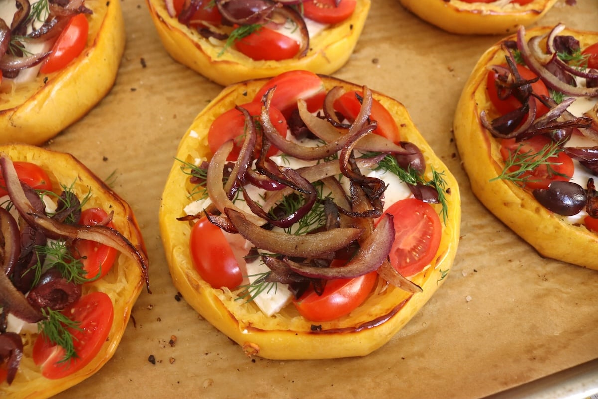 Spaghetti-Squash-Rings-with-Feta-and-Olives Cooked spaghetti squash ring with feta, red onion and tomatoes on top.