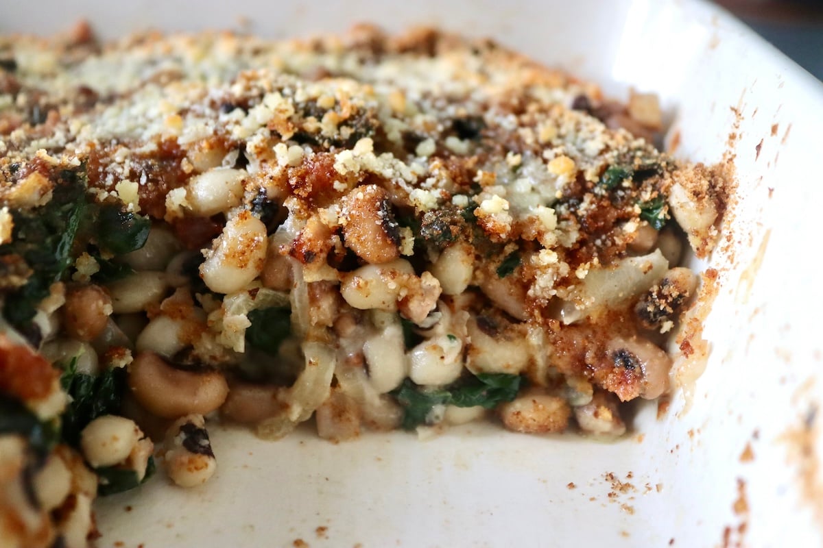 Black-Eyed Pea Casserole Golden Black-Eyed pea casserole in a square baking dish, with a slice removed.
