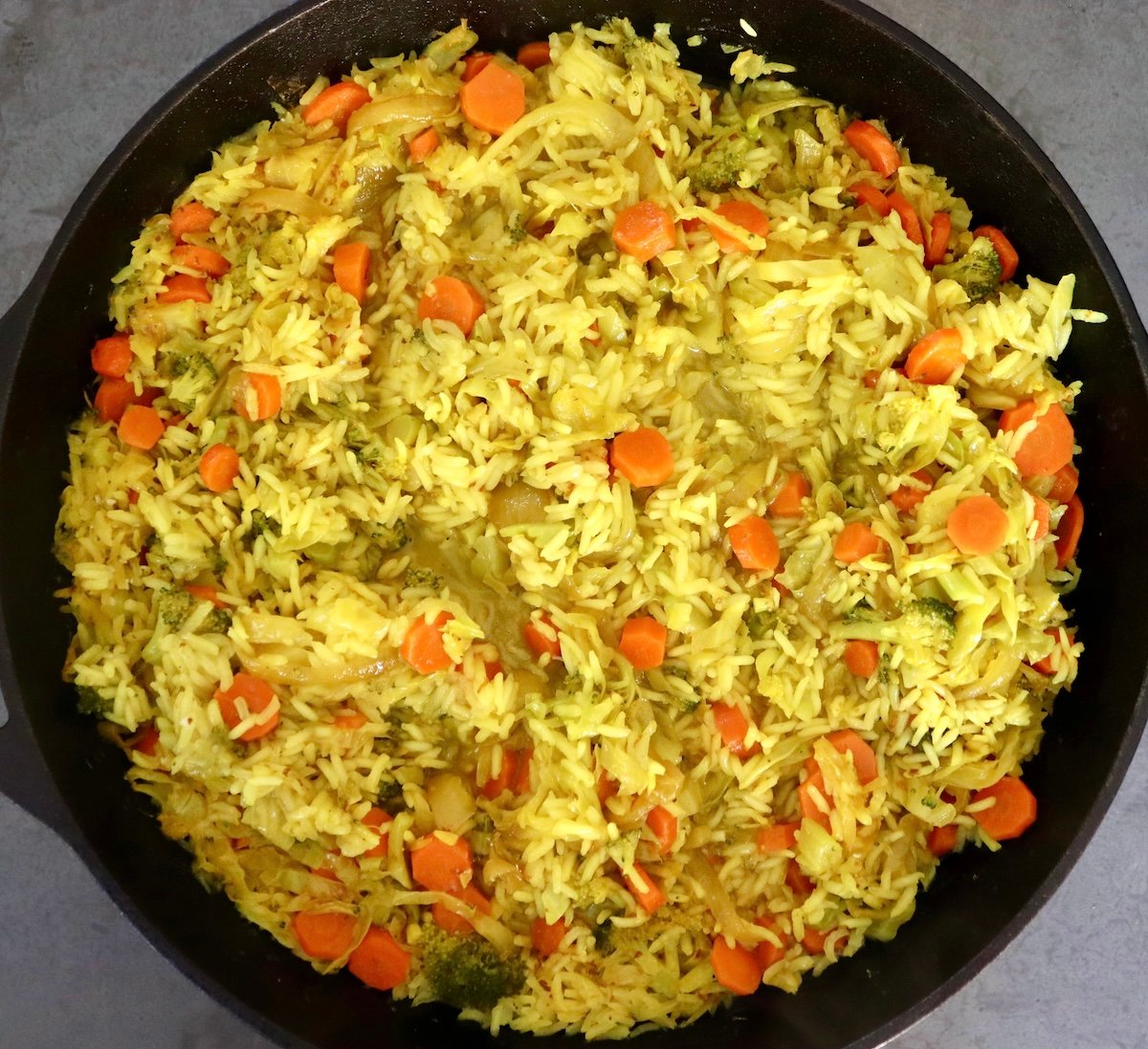 Baked-Red-Snapper-Recipe Large cast iron skillet filled with cabbage, broccoli, onion, carrots, rice a little bit of water.