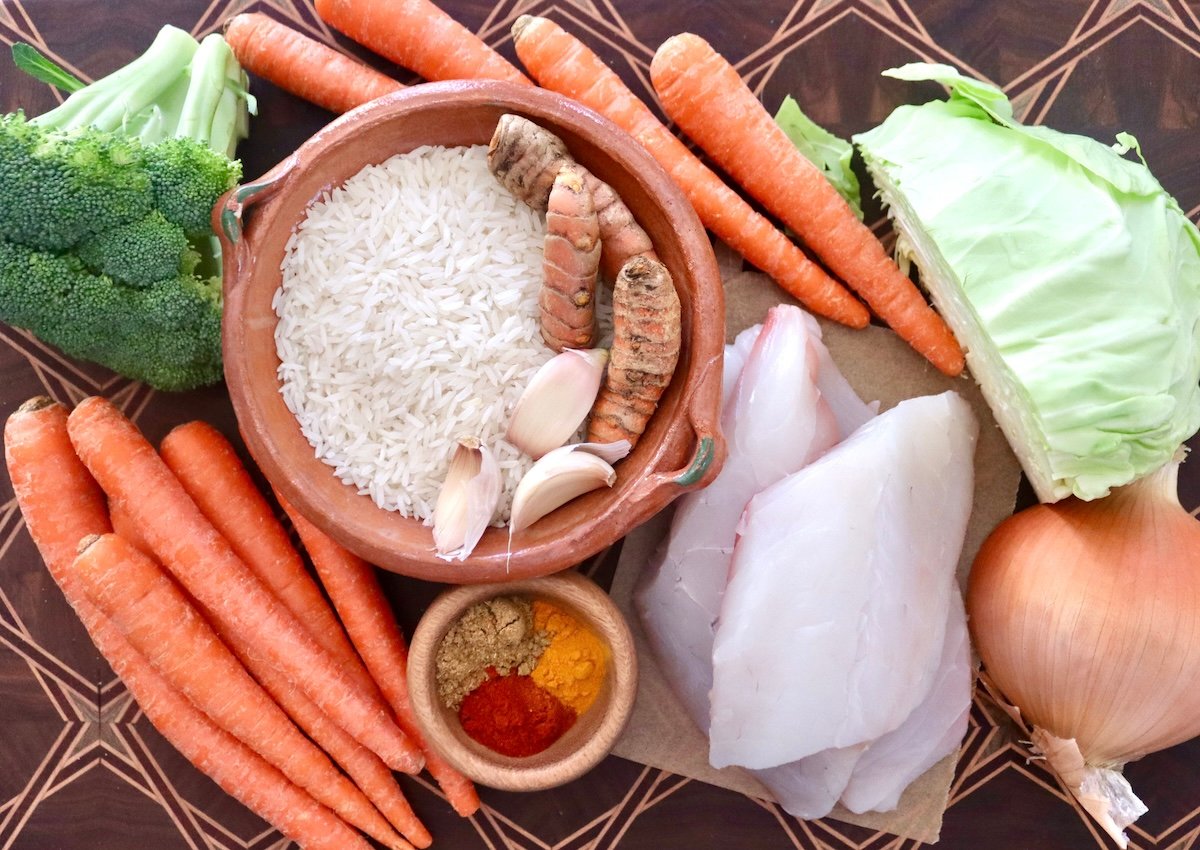 Baked-Red-Snapper-Recipe Ingredients for baked red snapper including, snapper fillets, carrots, fresh turmeric, garlic, onion, spices, cabbage and broccoli.