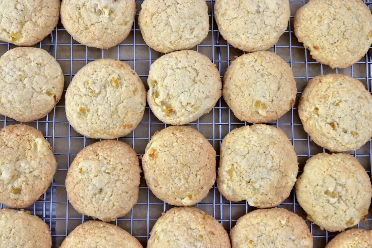Cornbread-Cookies-Recipe More than a dozen baked cornbread cookies on a cooling rack on a sheet pan.
