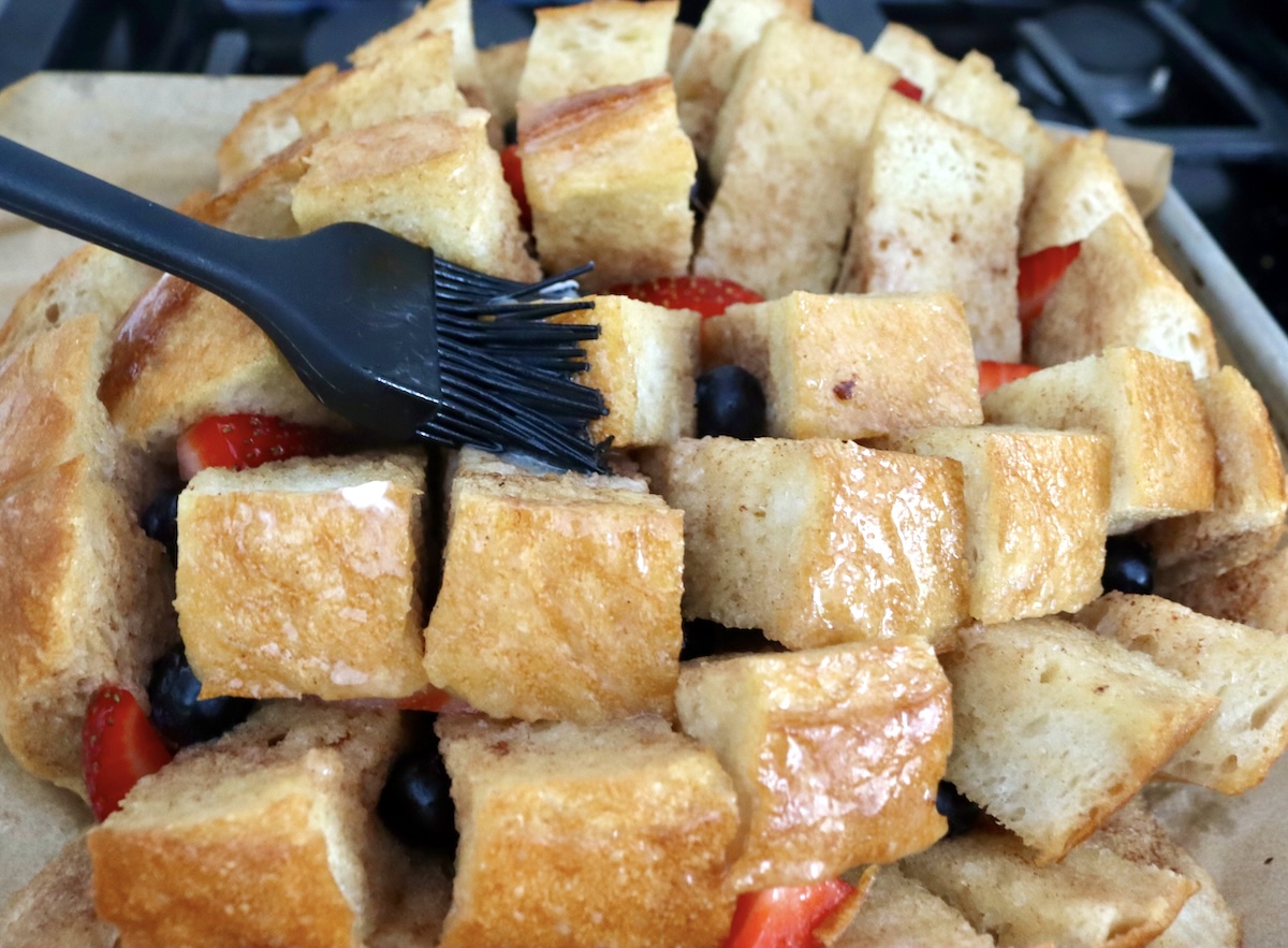 Pull-Apart French Toast Pull apart French toast with a few berries being brushed with melted butter.